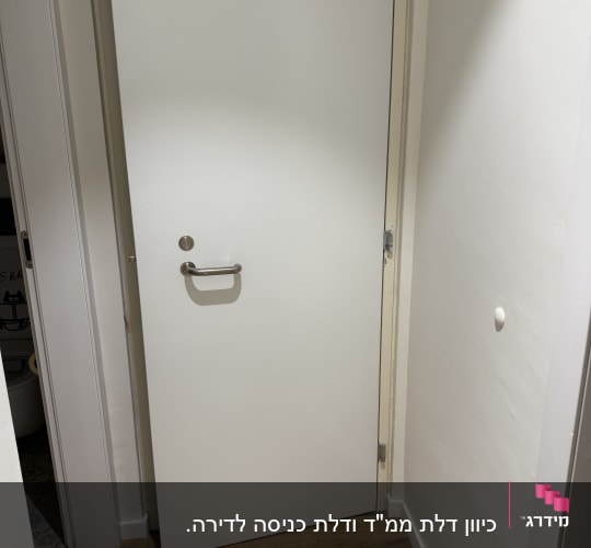 דלת לבנה עם ידית ומנעול כסופים